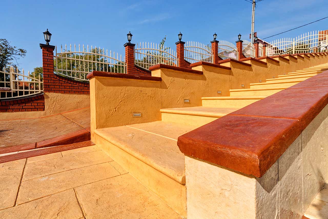 stamped concrete wall with steps and wrought iron