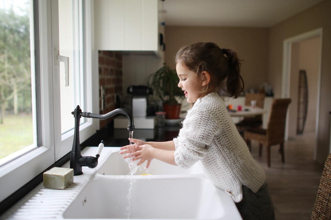 Girl washing her hands in the kitchen