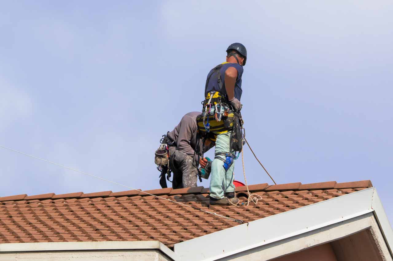 Two workers replacing broken tiles