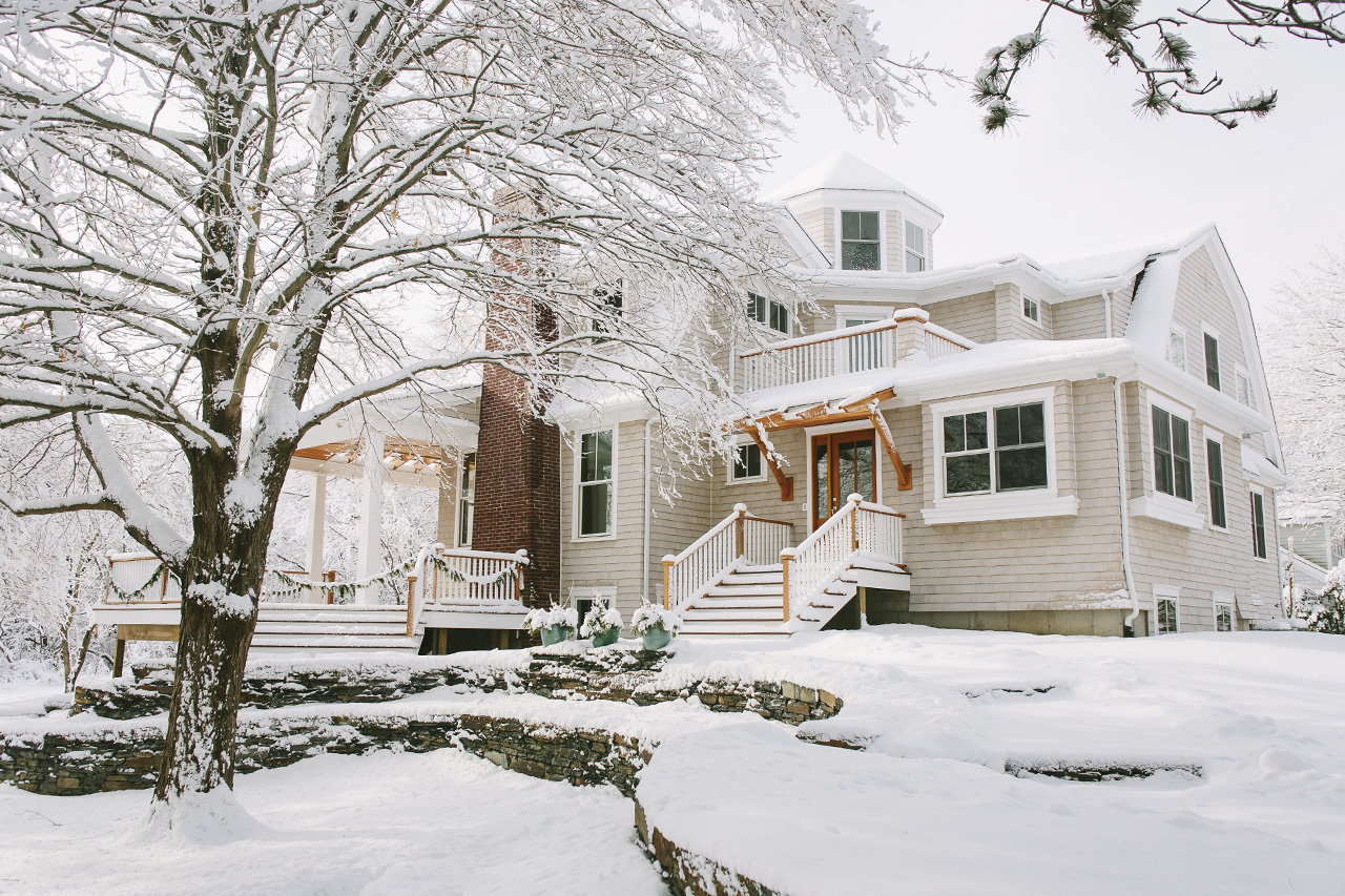 The exterior of a house with snow on roof