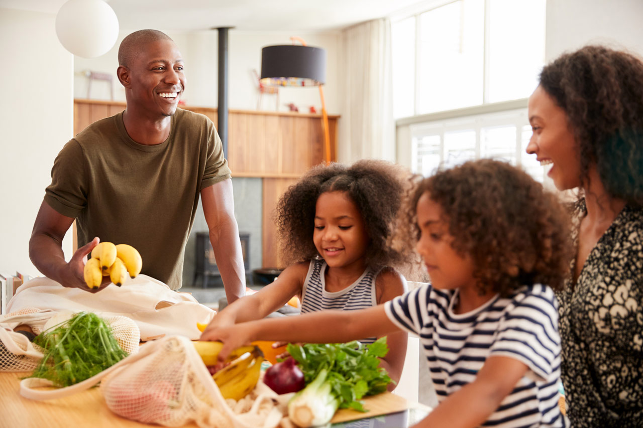 A family unpacking grocery bags