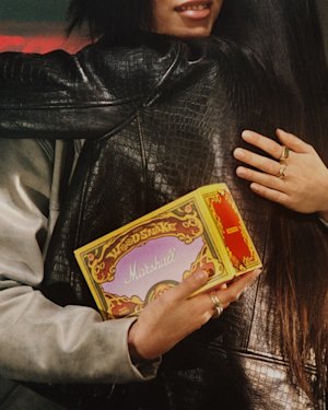Two people embrace, with one holding a colorful Marshall Emberton III Lunar New Year Edition 2025 box.