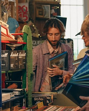 Un hombre con barba hojea los discos en una tienda de discos