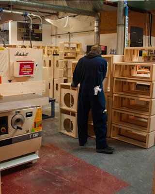A Marshall factory working cutting the frame for a Marshall amplifier