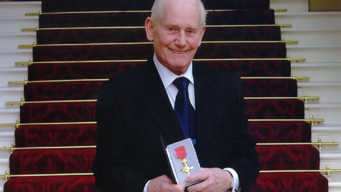 Jim Marshall en la escalinata del Palacio de Buckingham al recibir la Orden del Imperio Británico en 2003.