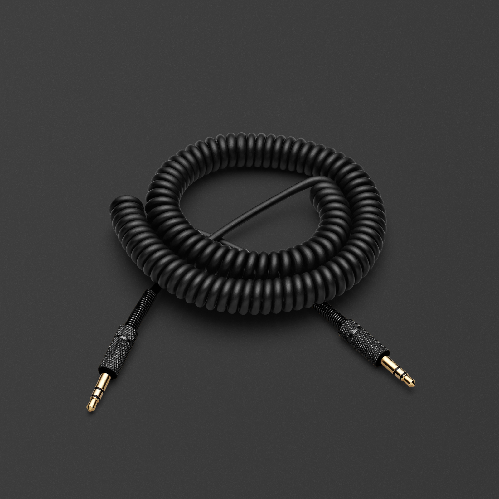 A pitch black coiled Marshall speaker audio cable on a black surface.