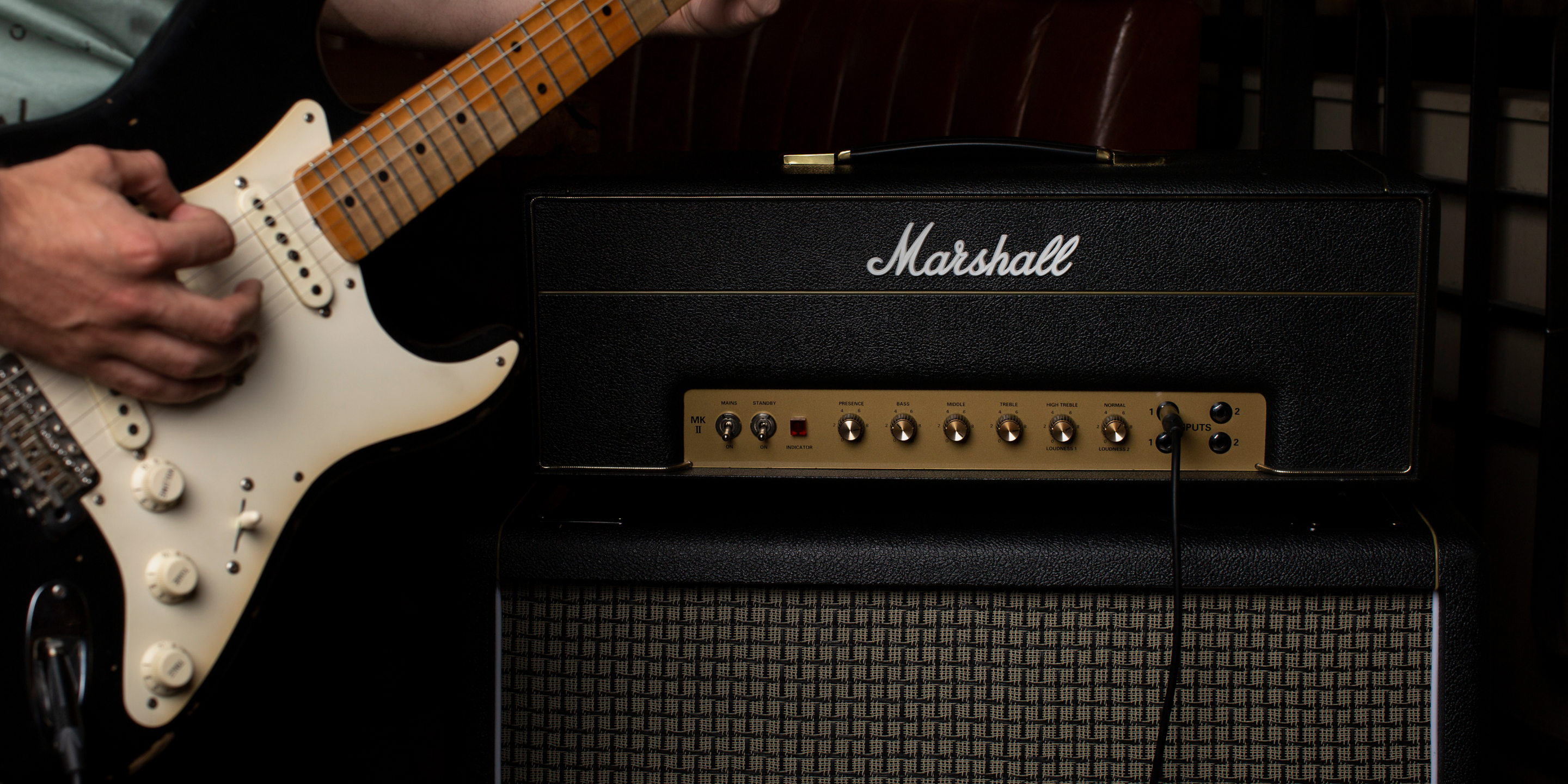 A person playing a guitar at a concert with the best amplifier for crunch sound. 