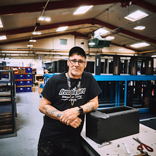 A worker from the UK factory posing next to an Amplifier in the making