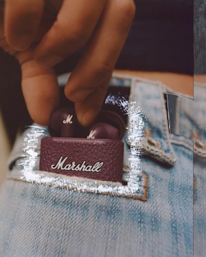 充電ケースにMarshall Minor III Burgundy Earbudsを戻す人。