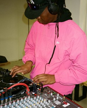 A DJ playing music on his music booth.
