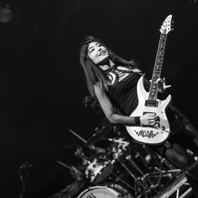 Black and white photo of Yuki playing guitar