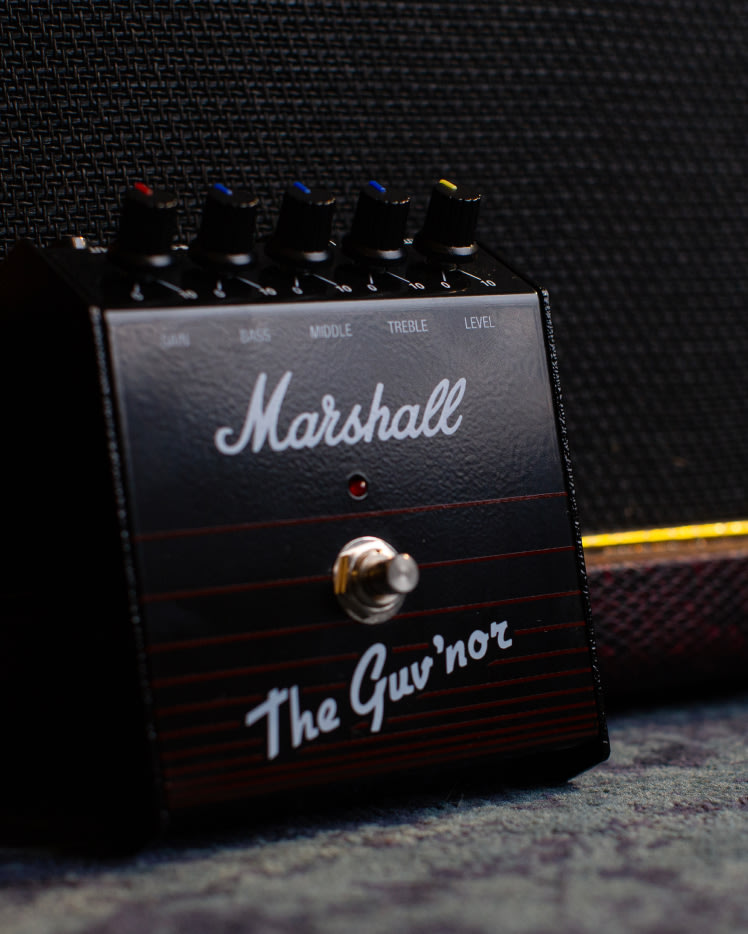 A Guv'nor Vintage Reissue Pedal standing against the wall.