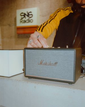 Interior de SNS Radio con una persona usando un Marshall Acton