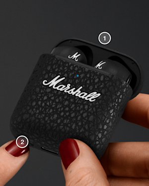 Mano con las uñas pintadas de rojo sujetando un maletín Minor III, mientras pulsa el botón Bluetooth de la parte inferior del maletín.