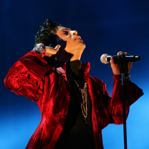 Prince en el escenario con un micrófono
