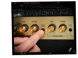 Una persona está ajustando los mandos de un amplificador de guitarra Marshall DSL20 Combo.