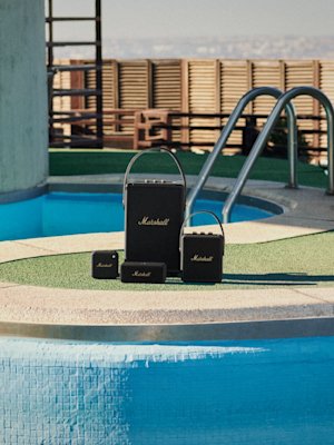 Marshall's black speakers in front of a swimming pool.