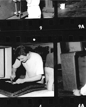 A black and white photo of a man working on a piece of furniture using the Marshall Studio Classic Combo.