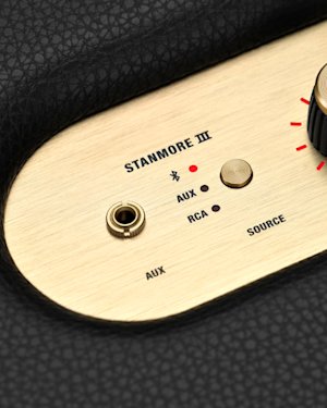 The AUX port and Source button on top of a Stanmore III speaker.