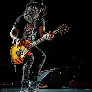 Slash playing guitar on stage