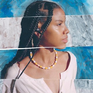 A side profile of a person with long braided hair, wearing Marshall's Motif II ANC wireless earbuds and a beaded necklace.