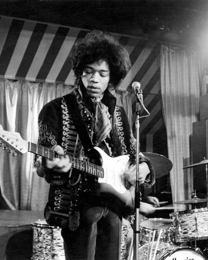 Jimi Hendrix playing guitar on stage