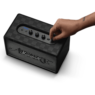 A hand adjusts the dial on a limited edition Marshall Acton III Awake NY Edition black bluetooth speaker.
