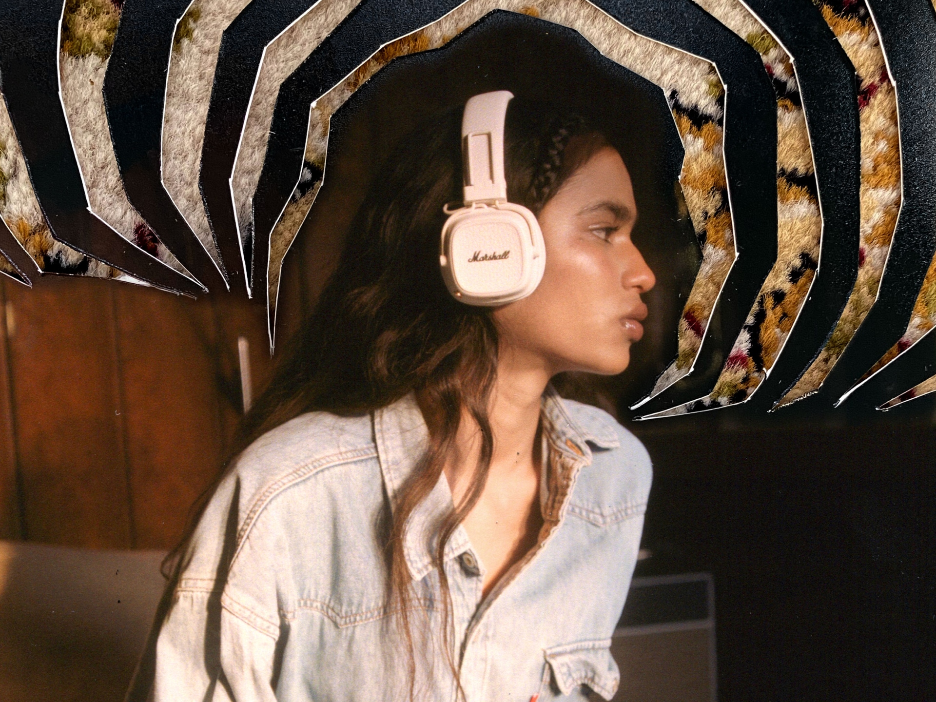 A woman in a denim outfit wearing Marshall Major V Cream on-ear headphones.