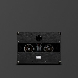 A black Marshall JVM 2x 12 guitar speaker cabinet viewed from the back, showing internal speakers, wiring, and a central circular component against a plain dark background.