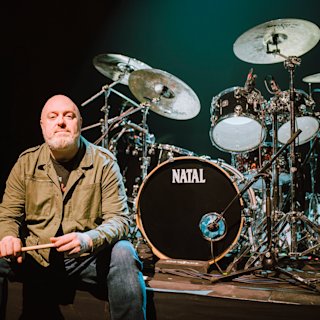 Steve Barney posing next to a green Natal drum kit