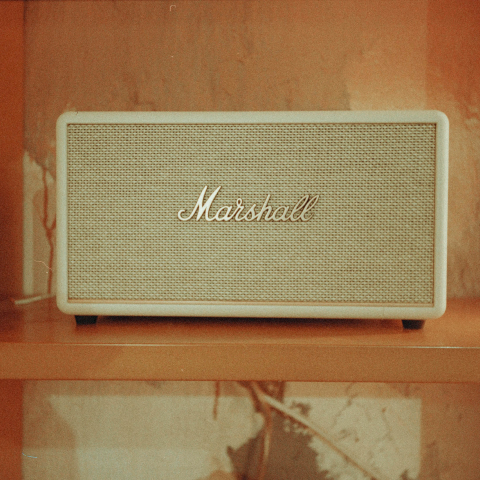 Altavoz marshall vintage en una estantería con fondo naranja retro.