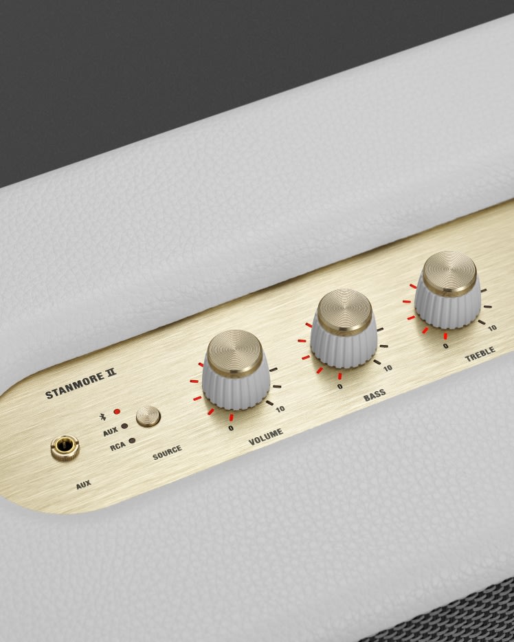 A close up of a Marshall Stanmore II Bluetooth White speaker with gold knobs.