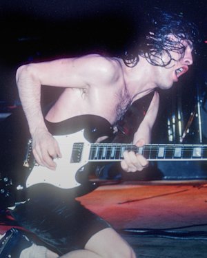 Angus Young performing at a concert.