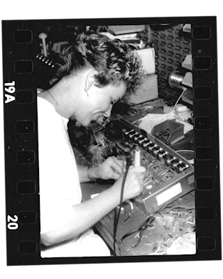 An old photo of a woman working on a computer with a Marshall JVM205 Head.