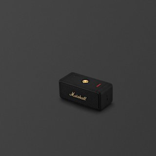 A Marshall Emberton II portable Bluetooth speaker in Black and Brass, with a brass control knob and logo, placed on a plain dark surface.
