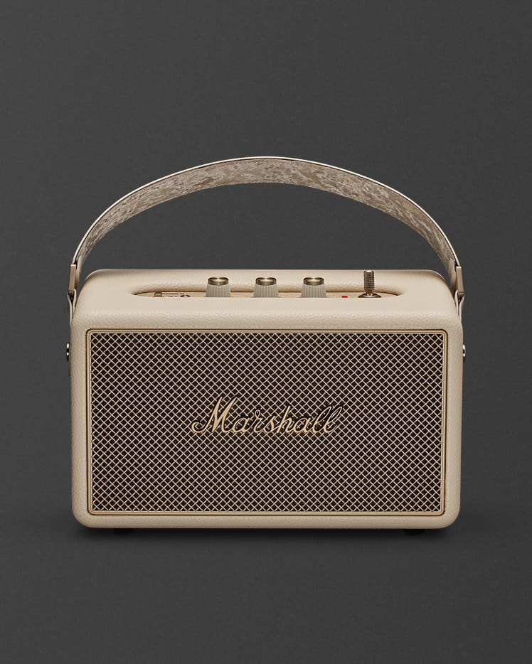 Marshall Kilburn III Cream portable Bluetooth speaker, featuring a mesh front, gold logo, top control knobs, and a handy carrying handle.