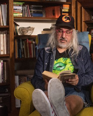Image de J Mascis assis dans un fauteuil et lisant