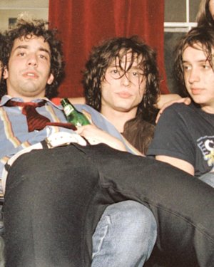 Indie band sat on a couch.