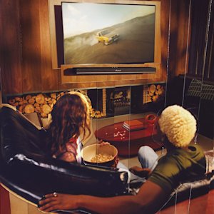 Friends watching a TV and listening to the Marshall Heston 120 TV sound bar