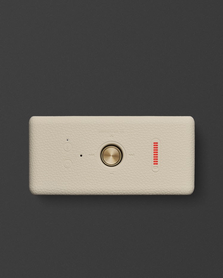 Marshall Emberton III Cream Bluetooth speaker with a gold knob and a vertical red LED indicator on a gray background.