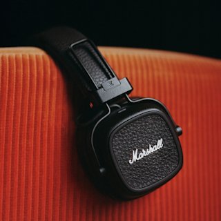 The Marshall Major V on-ear over a red arm chair.