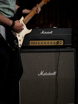 Guitarist playing his guitar whilst connected to the Marshall 1987X Vintage Reissue Head amplifier.