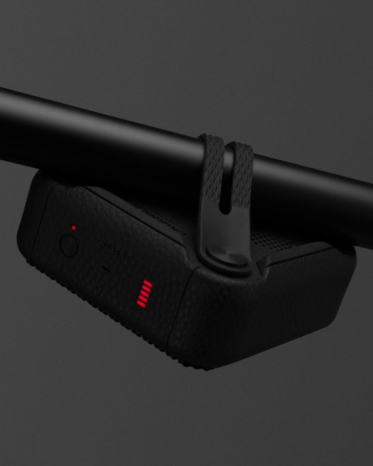 Un altavoz portátil Marshall Willen Black and Brass con un dispositivo negro y una luz roja conectada a él.