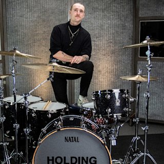 Ashley Green posing with a personalised Natal drum kit