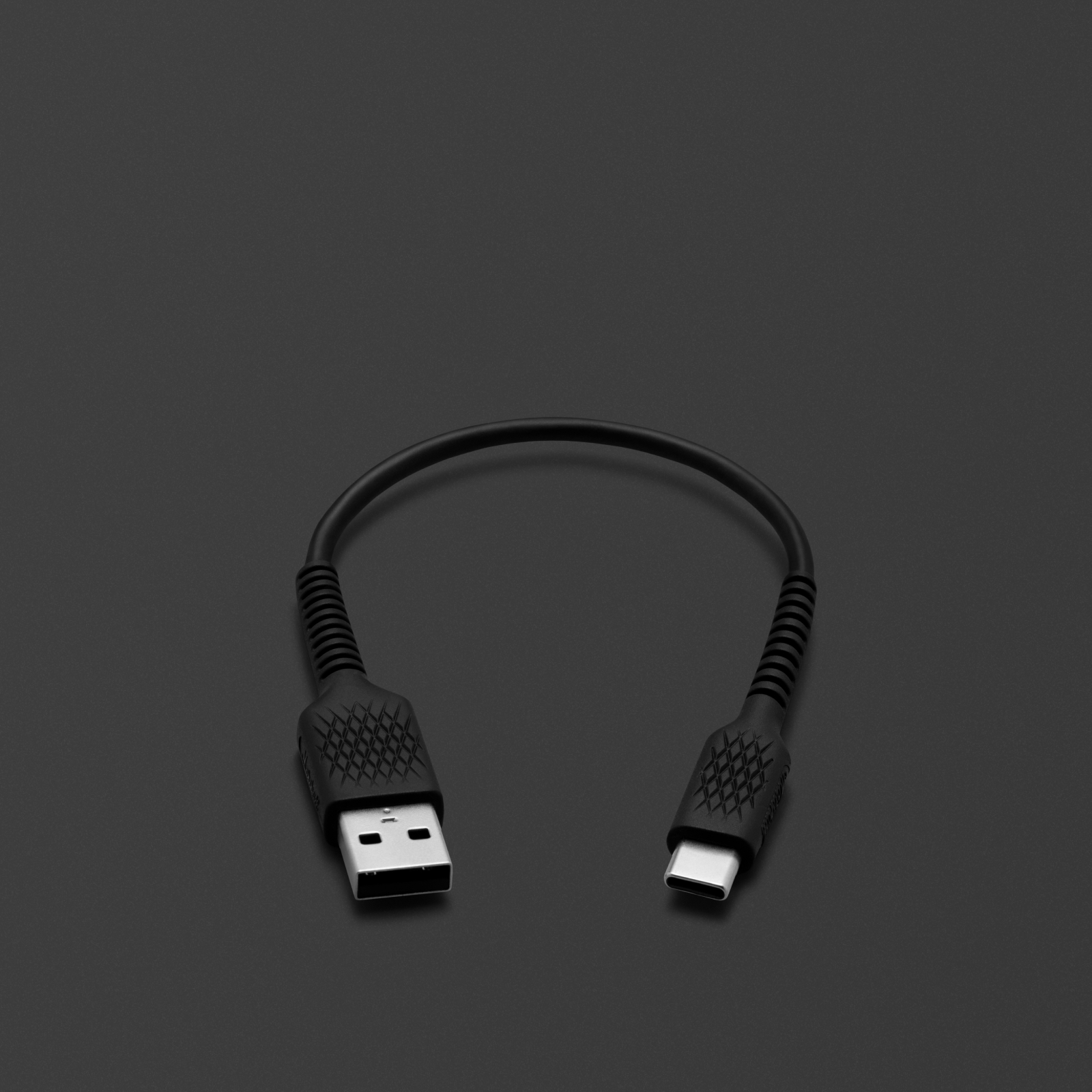 검은색 표면 위에 놓인 블랙 색상의 USB-C Marshall SHORT CHARGING CABLE.