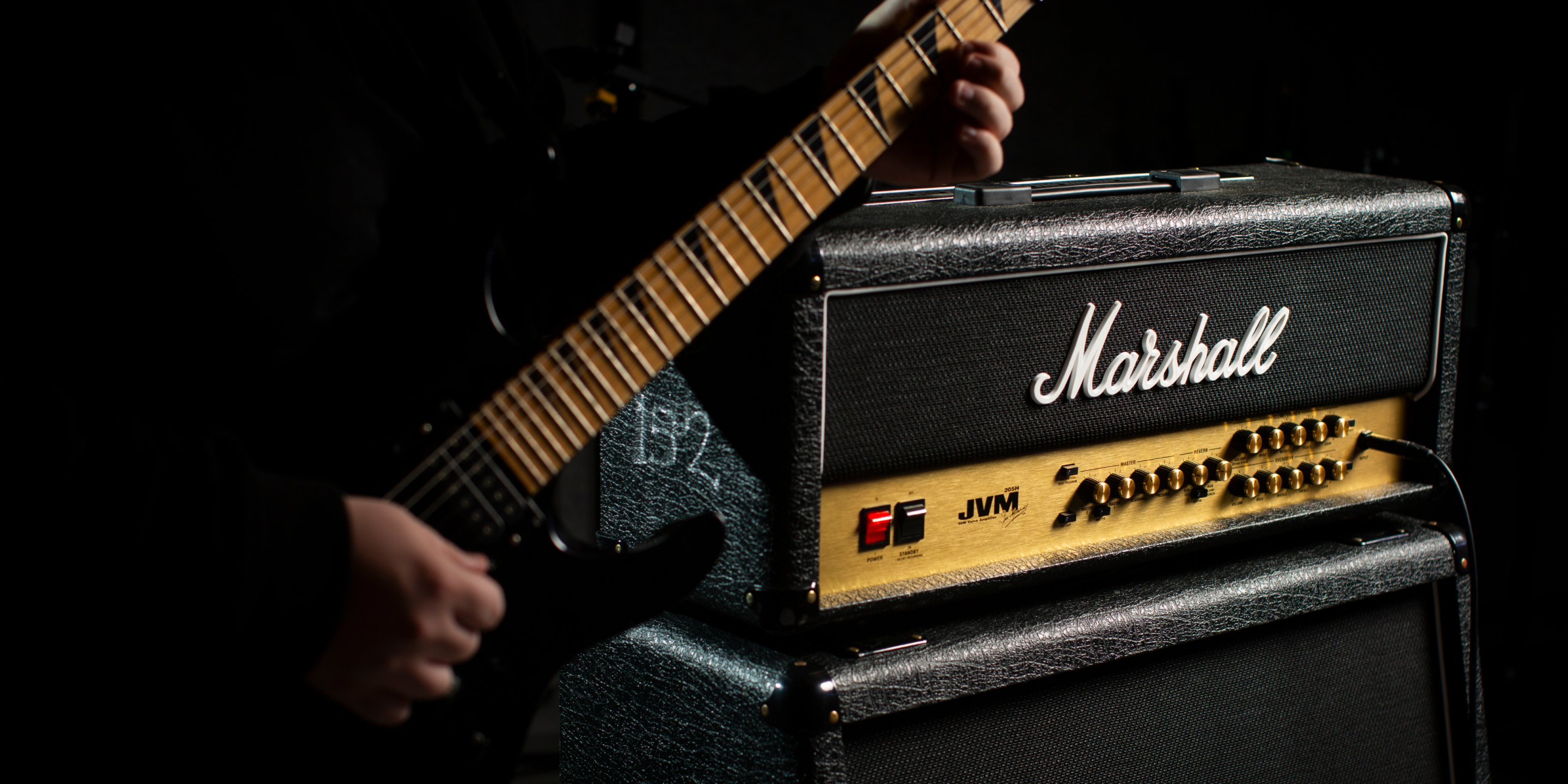 Una persona tocando una guitarra en el escenario con un amplificador y el mejor overdrive.