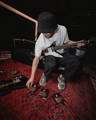 Un guitarrista ajustando los pedales de overdrive Marshall.