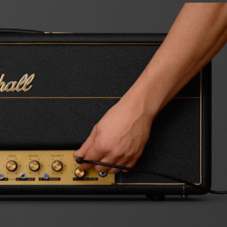 A person connecting a cable to the 1959 Modified amp by Marshall