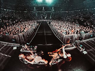 Nova Twins tocando la guitarra y el bajo en un concierto multitudinario.