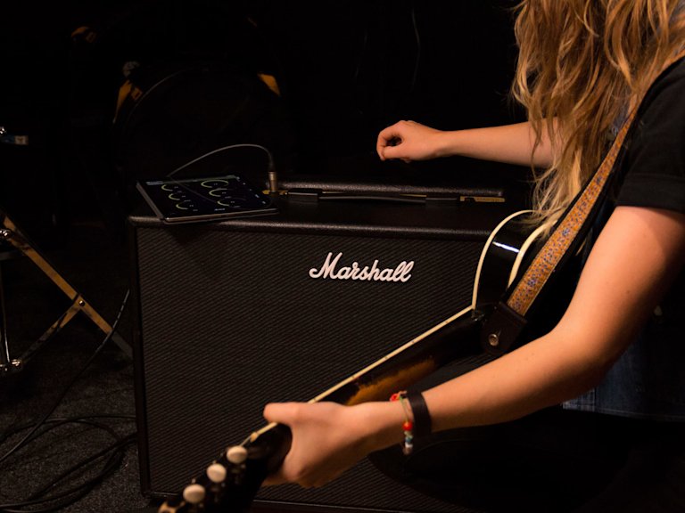 Una mujer afinando el Marshall CODE50 Combo usando la aplicación Code presets